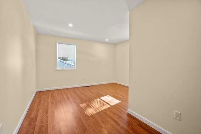 unfurnished room with recessed lighting, baseboards, and wood finished floors