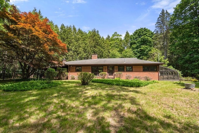 260 Landham Rd, Sudbury, MA 01776 - rear view of house with brick siding, a chimney, a lawn, and a wooded view