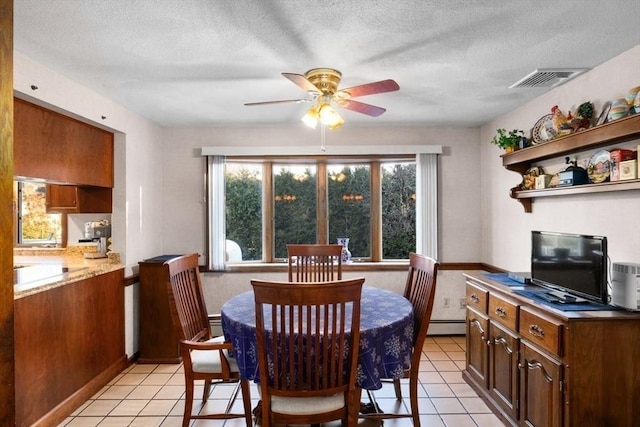 tiled dining area featuring ceiling fan, a textured ceiling, and a baseboard heating unit