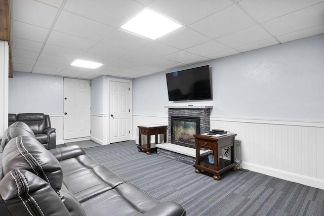 carpeted living room with a stone fireplace