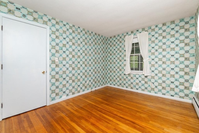 378 Linebrook Rd, Ipswich, MA 01938 - spare room featuring wallpapered walls, baseboards, wood finished floors, and a baseboard heating unit