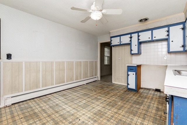 378 Linebrook Rd, Ipswich, MA 01938 - kitchen with baseboard heating, wainscoting, ceiling fan, light countertops, and blue cabinetry