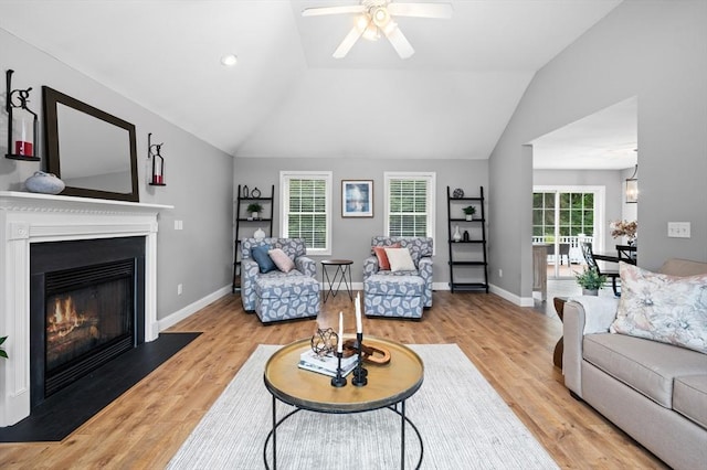 100 Overlook Ter, Dracut, MA 01826 - living area with lofted ceiling, a glass covered fireplace, a ceiling fan, and light wood-type flooring