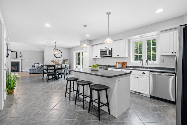 100 Overlook Ter, Dracut, MA 01826 - kitchen with stainless steel appliances, healthy amount of natural light, a kitchen breakfast bar, white cabinetry, and recessed lighting