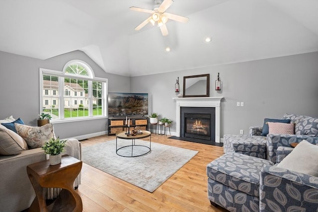 100 Overlook Ter, Dracut, MA 01826 - living area with vaulted ceiling, light wood finished floors, ceiling fan, and a fireplace with flush hearth