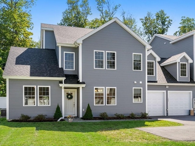 view of front of house featuring a garage, a front yard, central air condition unit, and driveway