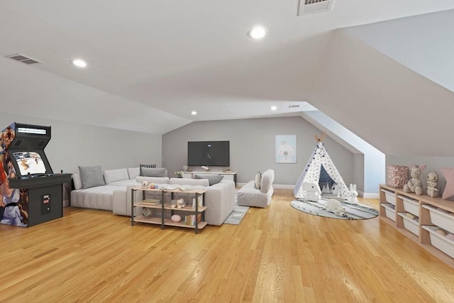 bedroom featuring light wood-style floors, lofted ceiling, and visible vents