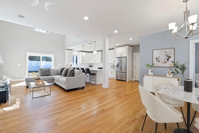 living area with visible vents, baseboards, a notable chandelier, recessed lighting, and light wood-style flooring