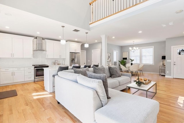 living area featuring recessed lighting, a notable chandelier, visible vents, and light wood-style flooring