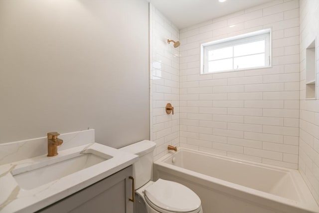 full bathroom featuring tiled shower / bath combo, toilet, and vanity