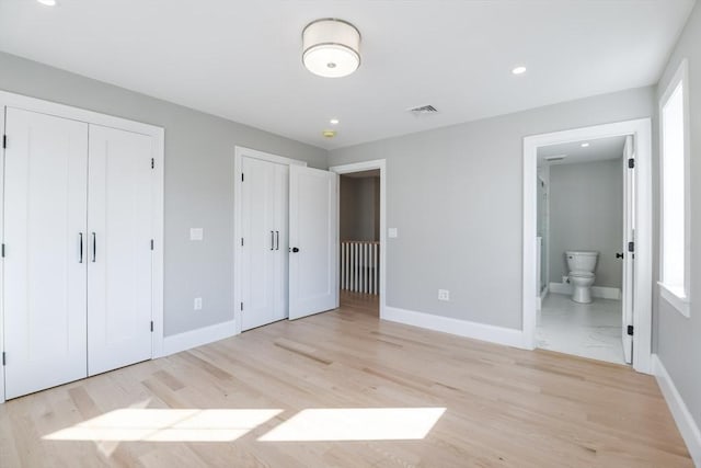 unfurnished bedroom with connected bathroom and light hardwood / wood-style flooring