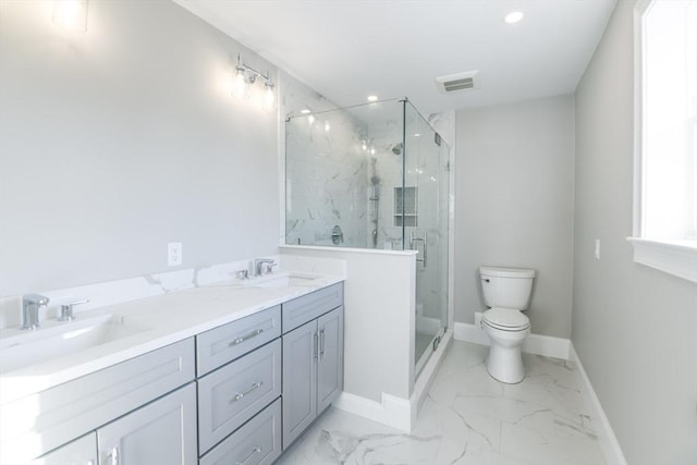 bathroom featuring vanity, a shower with shower door, and toilet