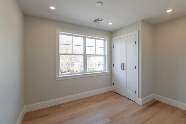 unfurnished bedroom featuring a closet and light hardwood / wood-style flooring