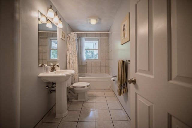 full bath featuring tile patterned floors, toilet, shower / tub combo with curtain, and a sink
