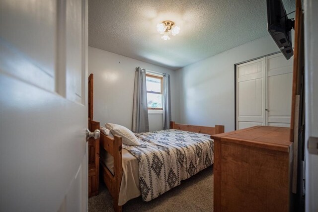carpeted bedroom featuring a textured ceiling