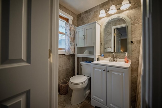 half bath featuring tile walls, toilet, and vanity