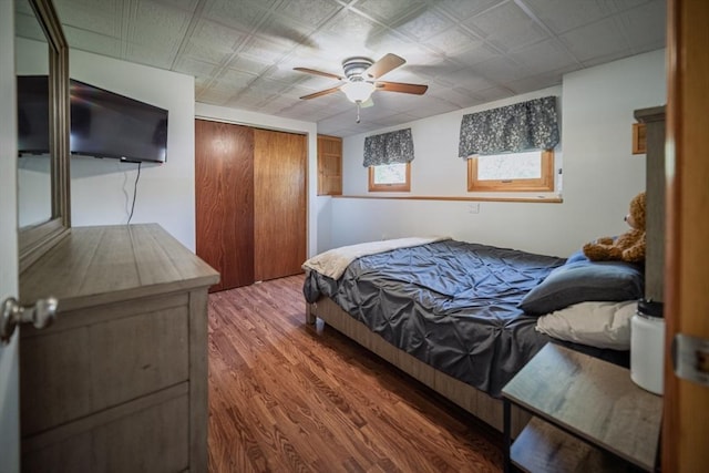 bedroom featuring a closet, wood finished floors, and ceiling fan