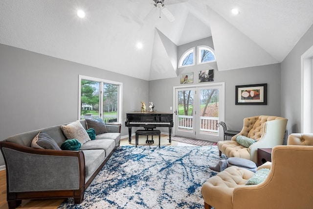 living area with wood finished floors, baseboards, ceiling fan, high vaulted ceiling, and recessed lighting