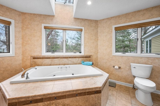 bathroom with toilet, a wealth of natural light, and a jetted tub