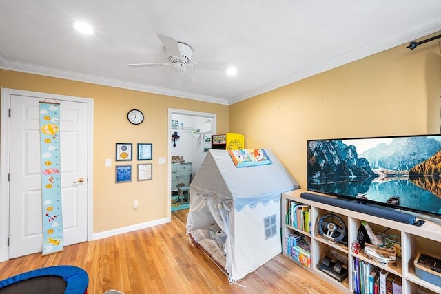 rec room featuring a ceiling fan, wood finished floors, baseboards, ornamental molding, and recessed lighting