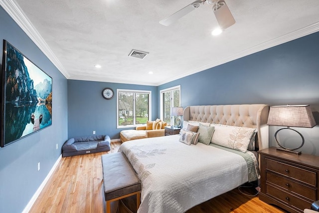 bedroom featuring baseboards, ornamental molding, wood finished floors, and visible vents