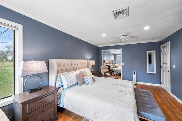 bedroom with visible vents, wood finished floors, and multiple windows