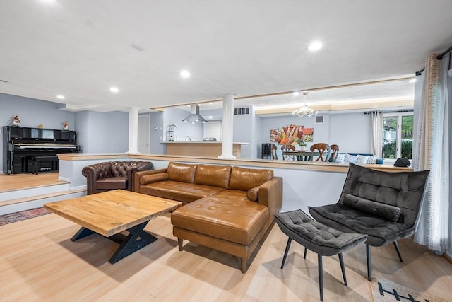 living area with recessed lighting, decorative columns, wood finished floors, and visible vents
