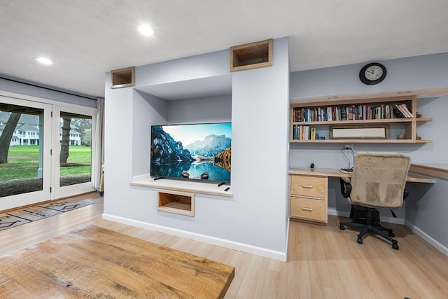 office with built in study area, baseboards, and light wood-type flooring