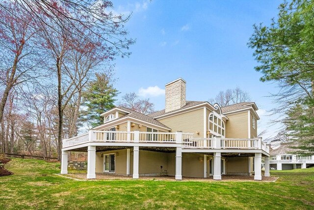 rear view of house featuring a lawn, a chimney, and a deck