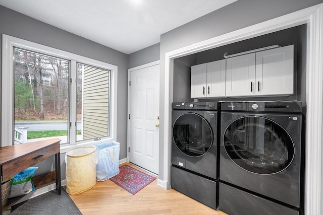 washroom featuring plenty of natural light, light wood-style flooring, cabinet space, and independent washer and dryer