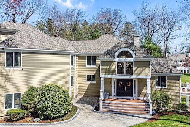 view of front of house featuring a shingled roof and a chimney