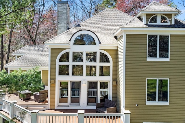 rear view of property with a chimney and a deck