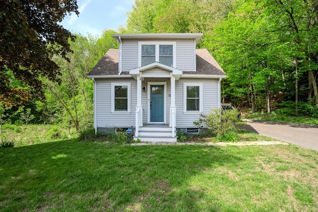 bungalow-style house featuring a front lawn and roof with shingles