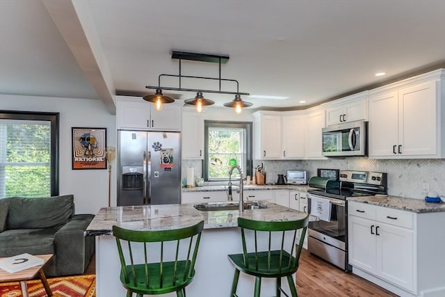 kitchen with appliances with stainless steel finishes, a sink, white cabinets, decorative backsplash, and recessed lighting