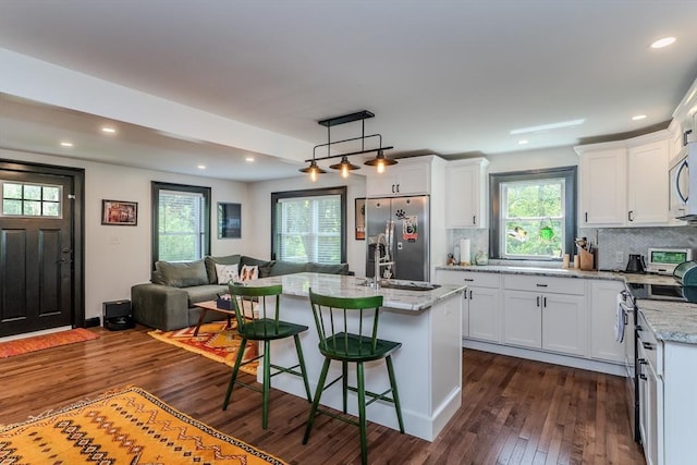 kitchen featuring appliances with stainless steel finishes, open floor plan, dark wood finished floors, white cabinetry, and recessed lighting