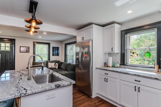 kitchen featuring stainless steel refrigerator with ice dispenser, a sink, dark wood finished floors, white cabinetry, and recessed lighting