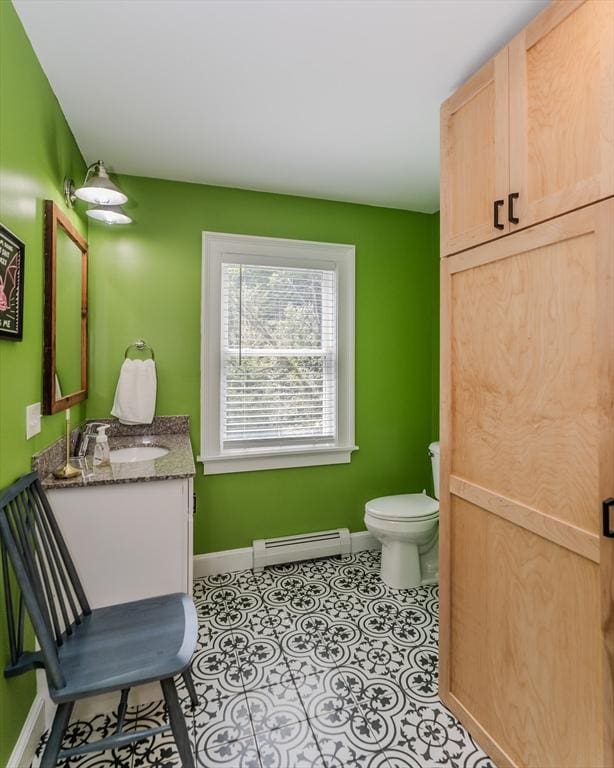 bathroom featuring a baseboard radiator, baseboards, toilet, and vanity