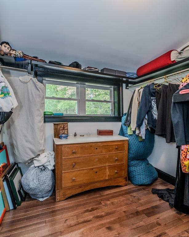 walk in closet with wood finished floors
