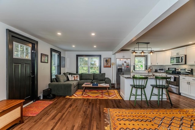 living room featuring dark wood finished floors, recessed lighting, and healthy amount of natural light