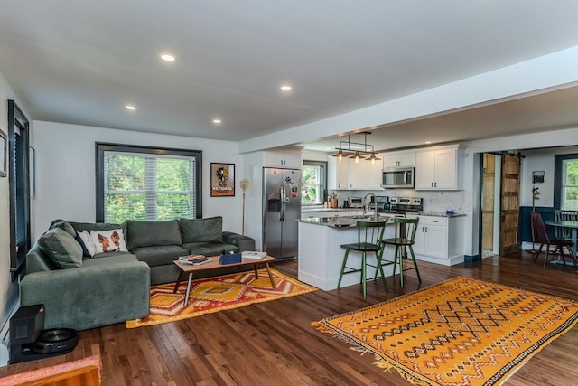living area with dark wood-style floors and recessed lighting