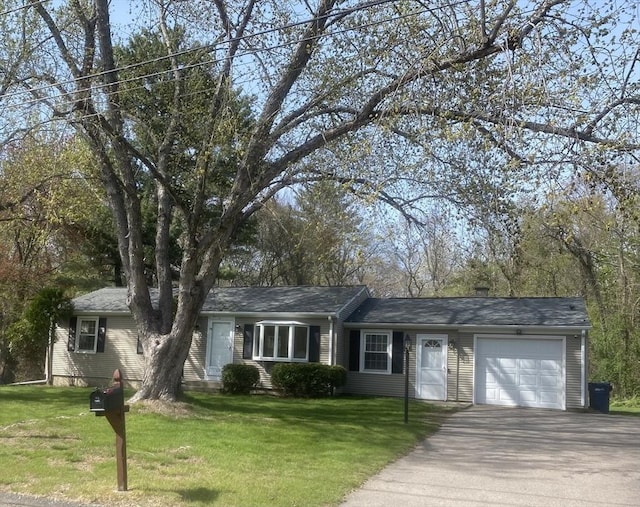 ranch-style house with a garage, a front yard, and aphalt driveway