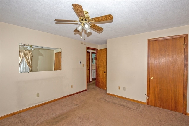 carpeted spare room featuring ceiling fan and a textured ceiling