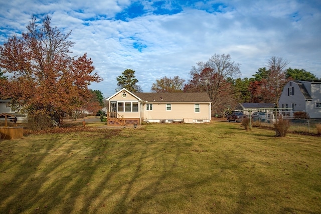 rear view of property with a lawn and a sunroom