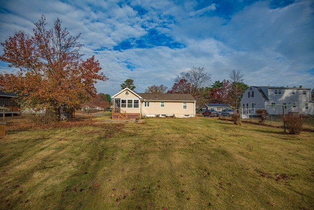 back of house featuring a lawn and a sunroom