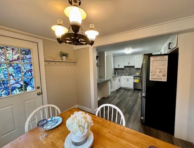 dining room featuring a notable chandelier, dark hardwood / wood-style floors, and crown molding