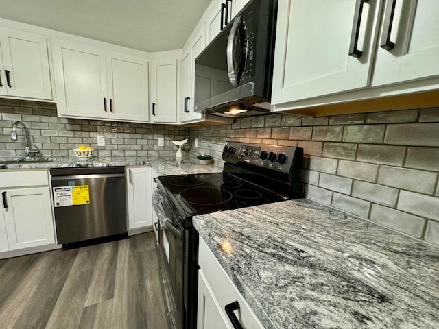 kitchen featuring tasteful backsplash, hardwood / wood-style floors, white cabinets, sink, and appliances with stainless steel finishes