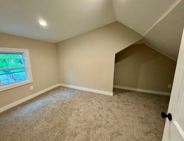 additional living space featuring carpet floors and vaulted ceiling