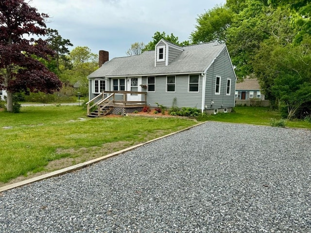 cape cod house featuring a front yard and a deck