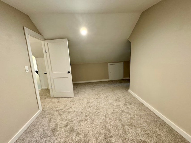 additional living space with lofted ceiling and light carpet