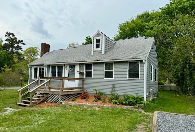 cape cod home featuring a front yard and a wooden deck